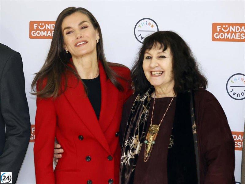 Reina Letizia irrumpe con un traje rojo vibrante y mocasines chunky en un día nublado.